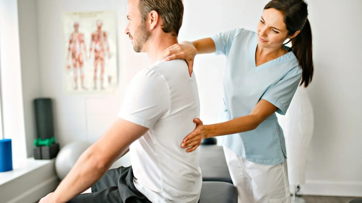 Chiropractor examining work injury patient